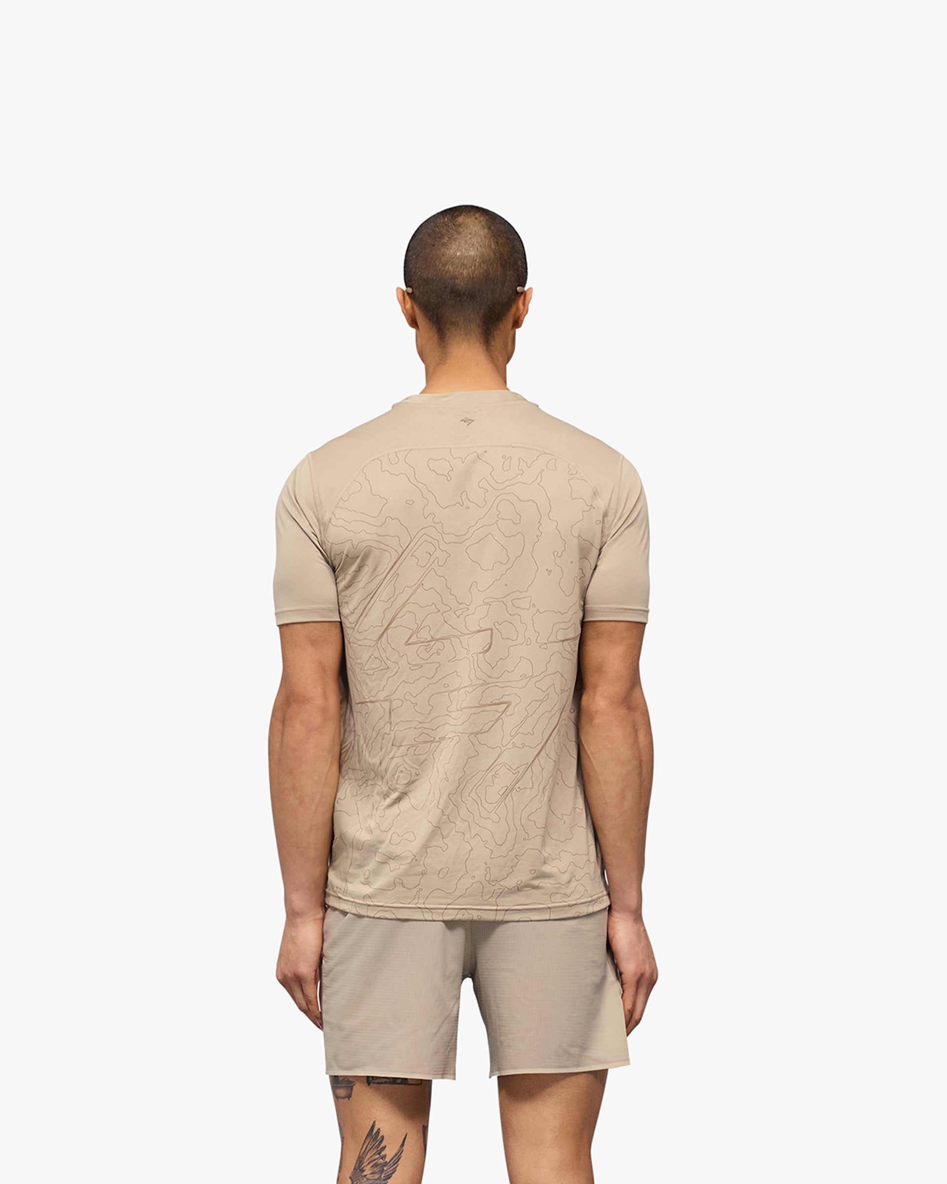 Man wearing a pebble grey running t-shirt on a plain white background | 247 Contour Run T-Shirt in Pebble | Breathable quick-dry running t-shirt with contour print | 247 T-Shirts | Represent Clo