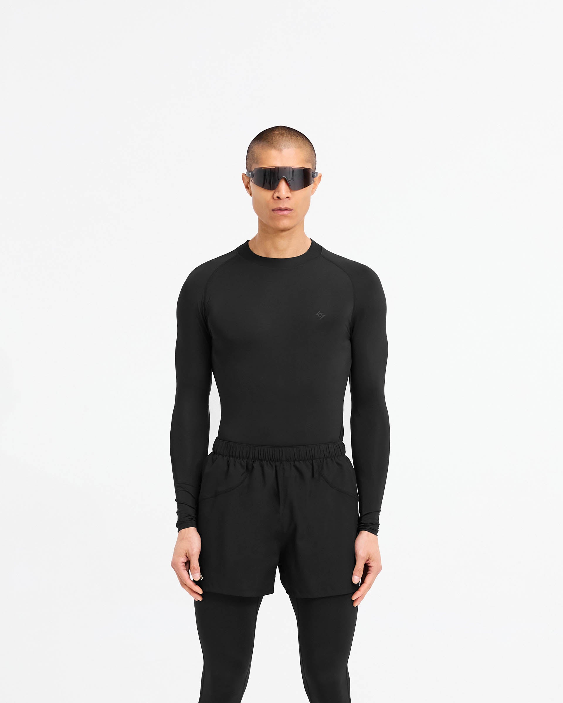 Man wearing a black long sleeve t-shirt on a plain white background | 247 Compound Long Sleeve T-Shirt in Black | Performance t-shirt with raglan sleeves and flatlock stitching | 247 T-Shirts | Represent Clo